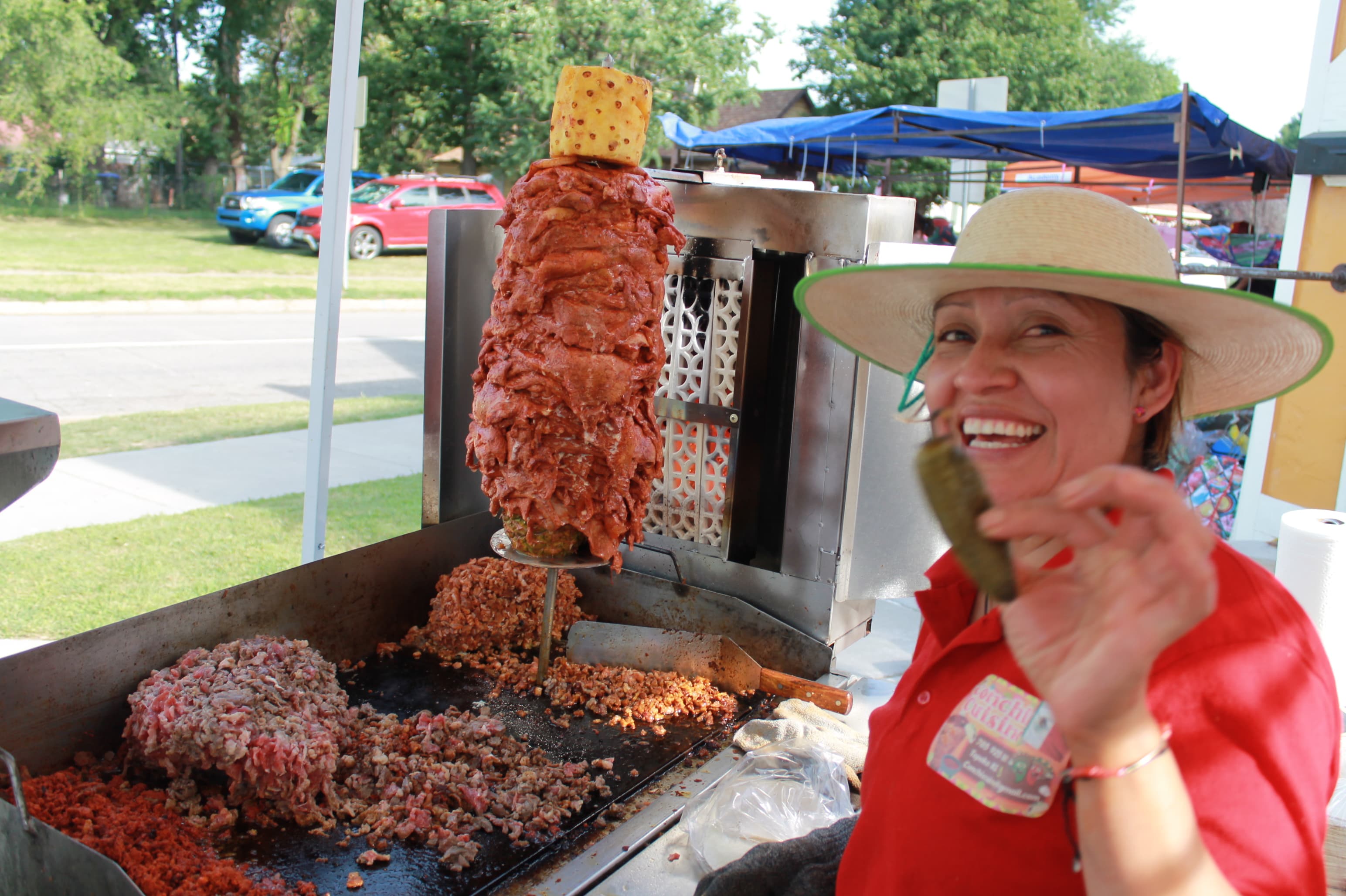 Conchis cuisine showing a jalapeño to the camera as the meat is cooking for her food event