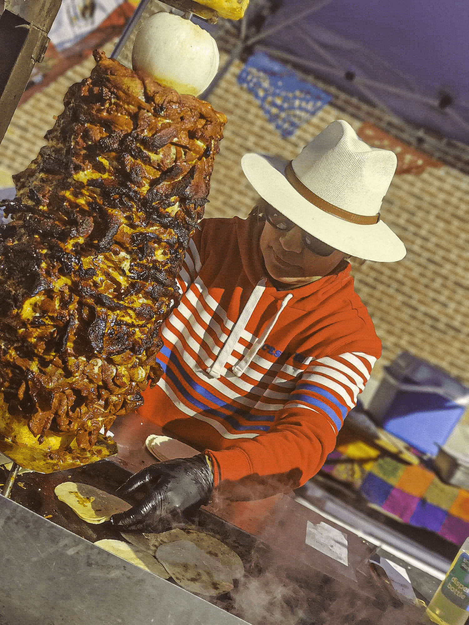 Cooking a trompo while cooking meats and preparing tacos